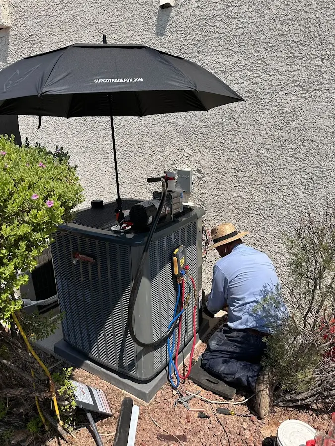 HVAC technician performing outdoor AC maintenance in Lawton