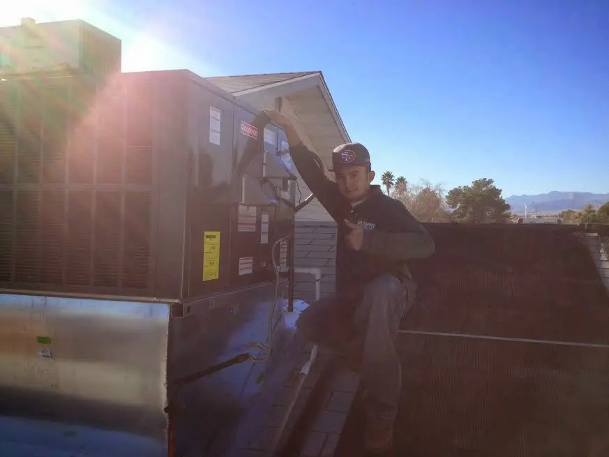 HVAC technician performing Air Duct Cleaning on a rooftop unit in Lawton